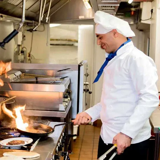 Whispering Pines Chef Created Meals, chef frying a dish.
