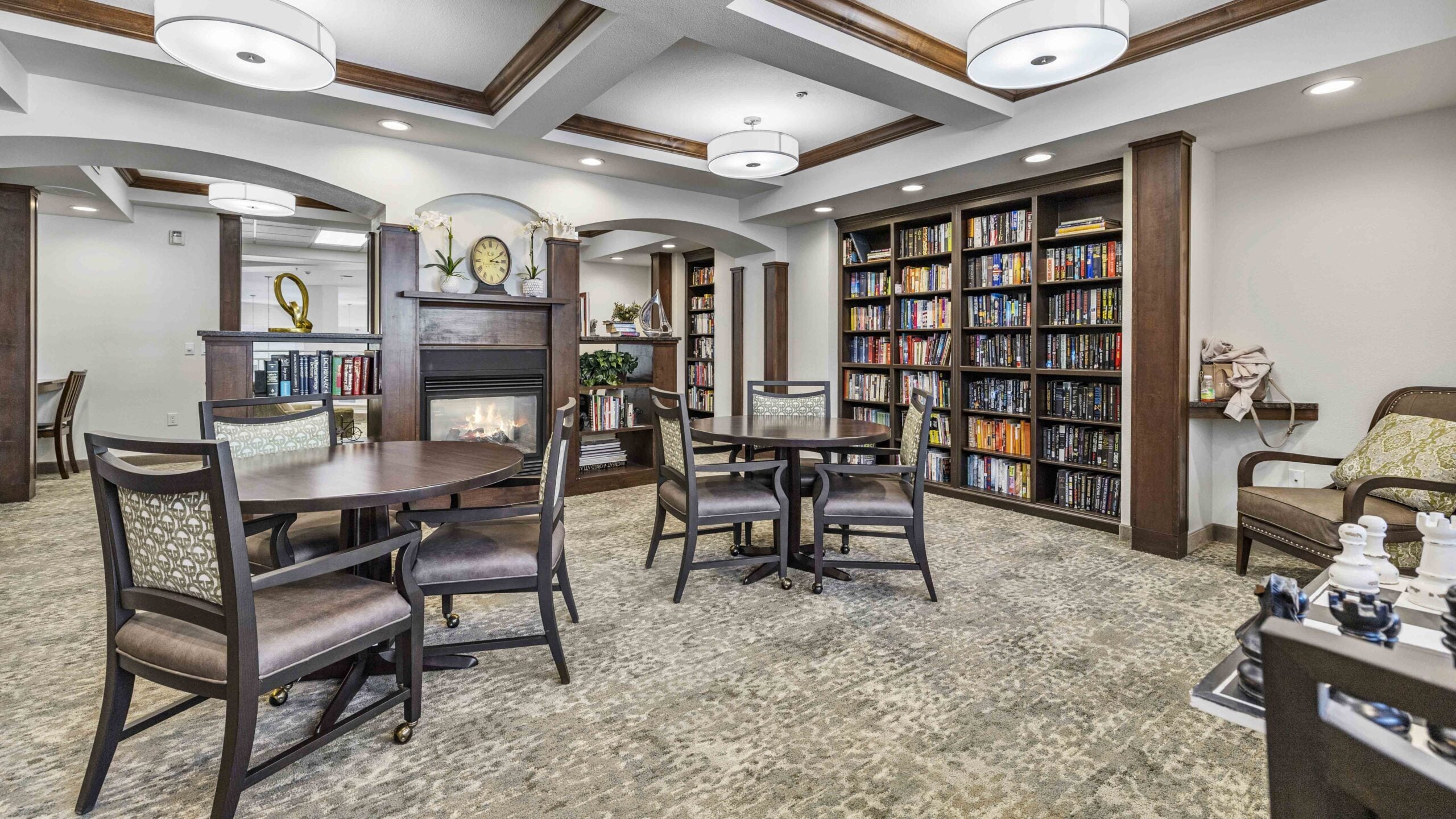 The library at Whispering Pines with shelves of books and comfortable seating