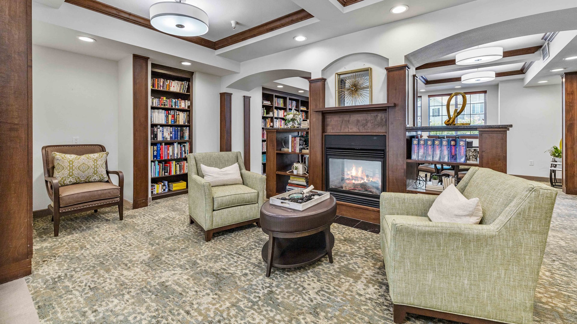 The library at Whispering Pines with shelves of books and comfortable seating