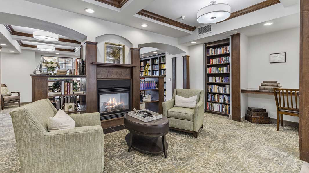 The library at Whispering Pines with shelves of books and comfortable seating
